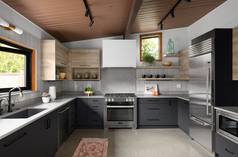 Inspiration for a mid-sized mid-century modern galley concrete floor, gray floor and wood ceiling eat-in kitchen remodel in Seattle with a single-bowl sink, flat-panel cabinets, black cabinets, quartz countertops, white backsplash, mosaic tile backsplash, stainless steel appliances, no island and gray countertops