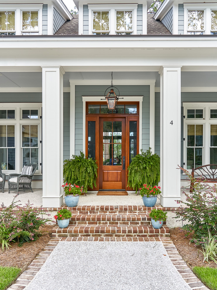 Design ideas for a large beach style front door in Charleston with a single front door, a medium wood front door and blue walls.