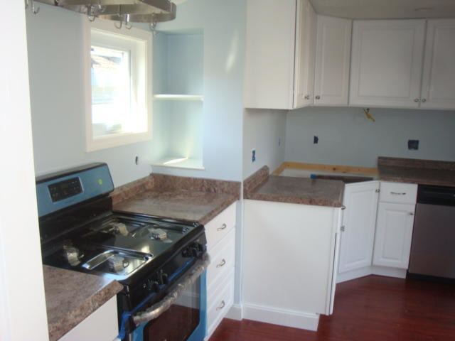 Kitchen - medium tone wood floor kitchen idea in Boston with raised-panel cabinets, white cabinets, granite countertops, blue backsplash, stainless steel appliances and no island