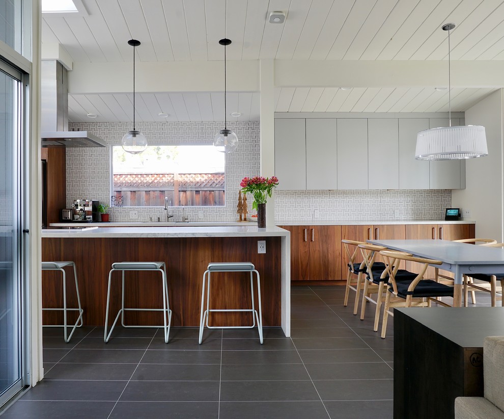 This is an example of a large midcentury galley eat-in kitchen in San Francisco with medium wood cabinets, white splashback, ceramic splashback, ceramic floors, a peninsula, grey floor and white benchtop.