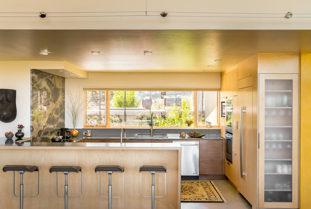 Contemporary kitchen in Denver with flat-panel cabinets, stone slab splashback, panelled appliances, a peninsula, concrete floors and grey floor.