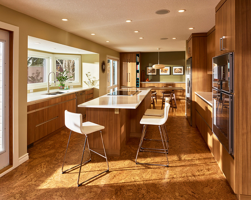 Inspiration for a midcentury eat-in kitchen in Edmonton with a double-bowl sink, flat-panel cabinets, quartz benchtops, stainless steel appliances, cork floors and with island.