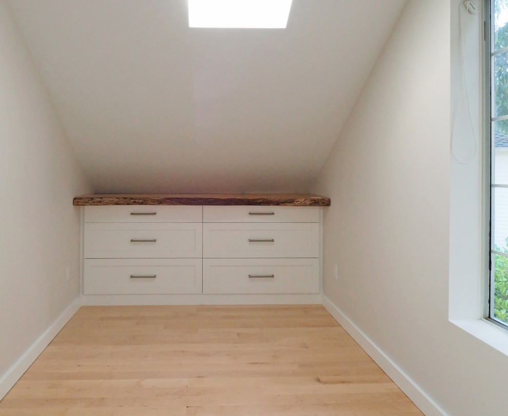 Small transitional storage and wardrobe in Tampa with light hardwood floors.