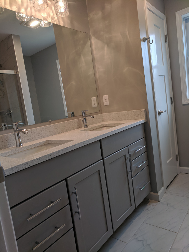 This is an example of a mid-sized traditional master bathroom in Other with grey cabinets, a curbless shower, a two-piece toilet, grey walls, ceramic floors, an undermount sink, engineered quartz benchtops, grey floor, a hinged shower door, multi-coloured benchtops, a niche, a double vanity, a built-in vanity and recessed-panel cabinets.