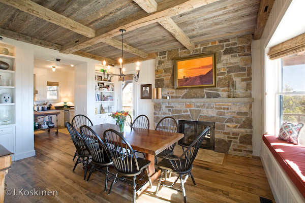 This is an example of a mid-sized country kitchen/dining combo in Denver with white walls, medium hardwood floors, a standard fireplace and a stone fireplace surround.