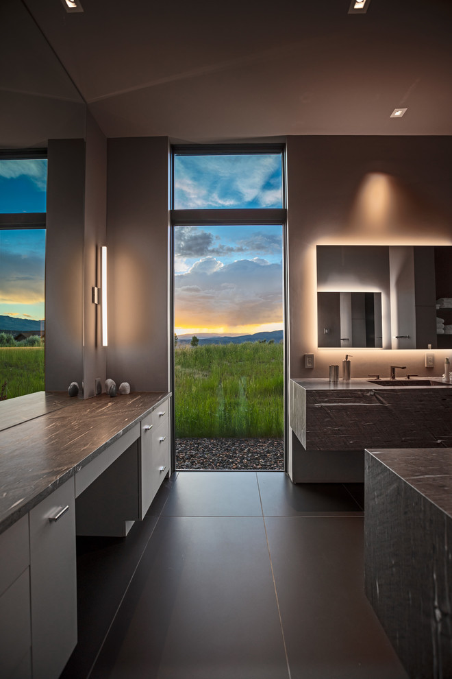 Photo of a mid-sized contemporary master bathroom in Denver with brown cabinets, a one-piece toilet, grey walls, porcelain floors, an undermount sink, limestone benchtops, grey floor and brown benchtops.