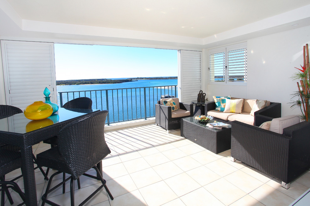 Mid-sized beach style balcony in Gold Coast - Tweed with a roof extension.