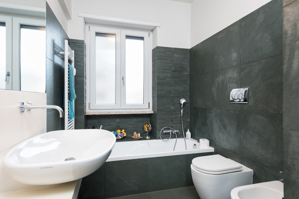 Photo of a contemporary master wet room bathroom in Rome with grey cabinets, a drop-in tub, a two-piece toilet, grey walls, dark hardwood floors and a vessel sink.