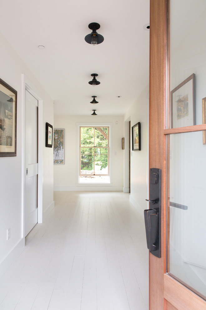 Photo of a large traditional front door in Portland Maine with white walls, painted wood floors, a single front door and a medium wood front door.