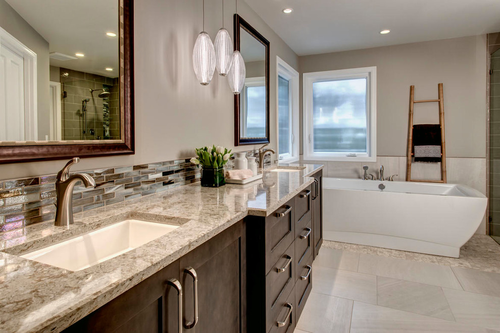 Example of a large transitional master multicolored tile and matchstick tile pebble tile floor freestanding bathtub design in Seattle with shaker cabinets, dark wood cabinets, a two-piece toilet, beige walls, an undermount sink and quartz countertops