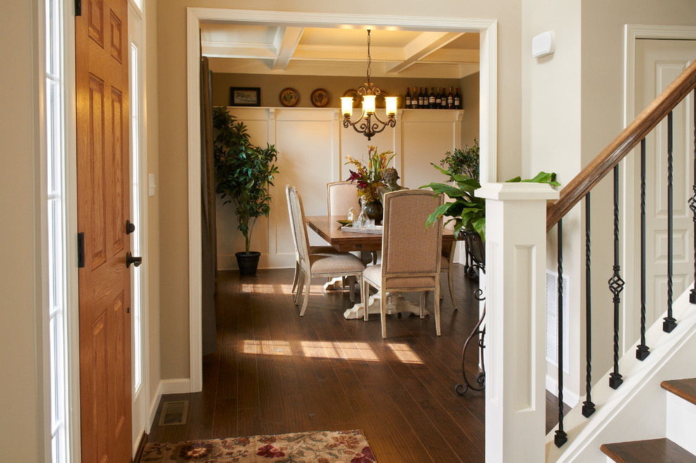 Example of a mid-sized transitional medium tone wood floor front door design with beige walls and a light wood front door