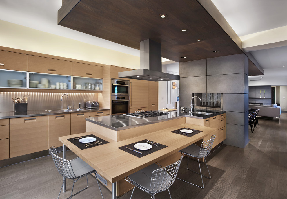 Mid-sized contemporary l-shaped open plan kitchen in Chicago with a double-bowl sink, flat-panel cabinets, light wood cabinets, wood benchtops, brown splashback, timber splashback, stainless steel appliances, dark hardwood floors, a peninsula and grey floor.