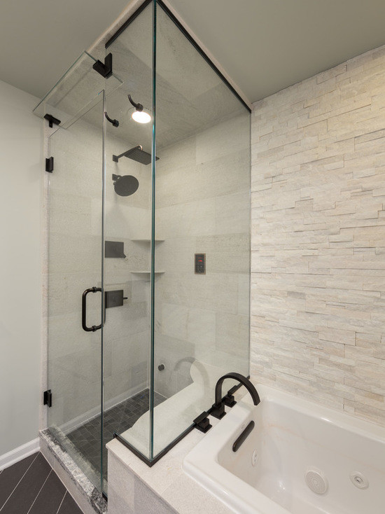 Inspiration for a mid-sized transitional master bathroom in Chicago with flat-panel cabinets, medium wood cabinets, a drop-in tub, an alcove shower, a one-piece toilet, black and white tile, marble, beige walls, ceramic floors, an undermount sink and limestone benchtops.