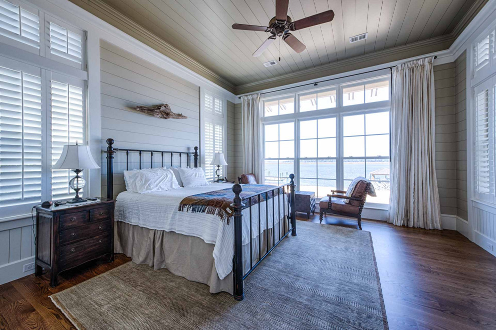 Hauptschlafzimmer mit beiger Wandfarbe, dunklem Holzboden, braunem Boden, Holzdielendecke und Holzdielenwänden in Sonstige