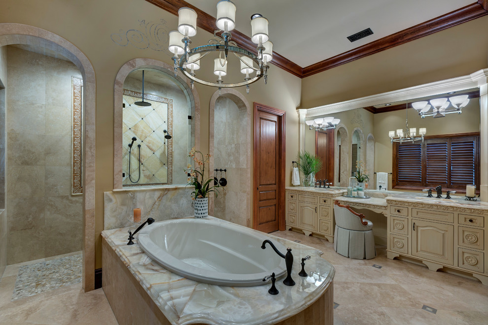 Photo of a large mediterranean master bathroom in Orlando with furniture-like cabinets, white cabinets, a drop-in tub, a double shower, beige tile, travertine, beige walls, travertine floors, an undermount sink, onyx benchtops, beige floor and an open shower.