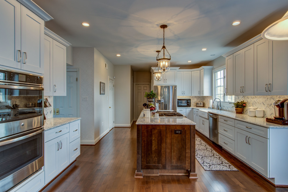 Inspiration for a large transitional u-shaped dark wood floor and brown floor eat-in kitchen remodel in DC Metro with a farmhouse sink, shaker cabinets, white cabinets, stainless steel appliances, an island, quartzite countertops, white backsplash, mosaic tile backsplash and white countertops