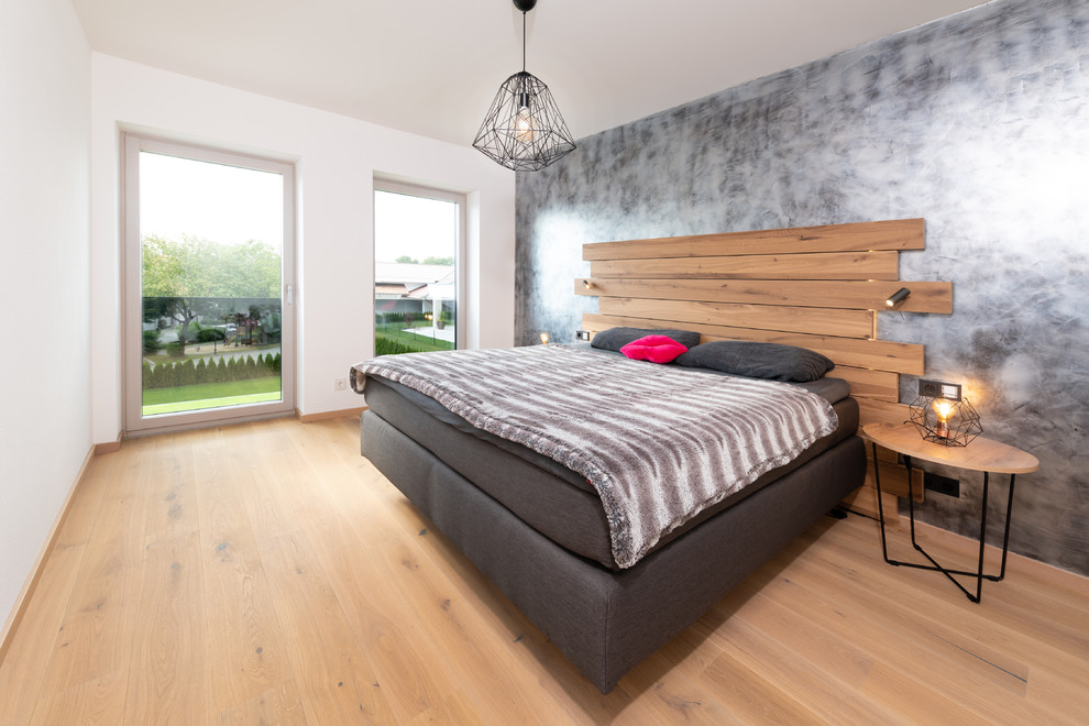 Foto de dormitorio principal actual de tamaño medio sin chimenea con paredes blancas, suelo de madera en tonos medios y suelo beige
