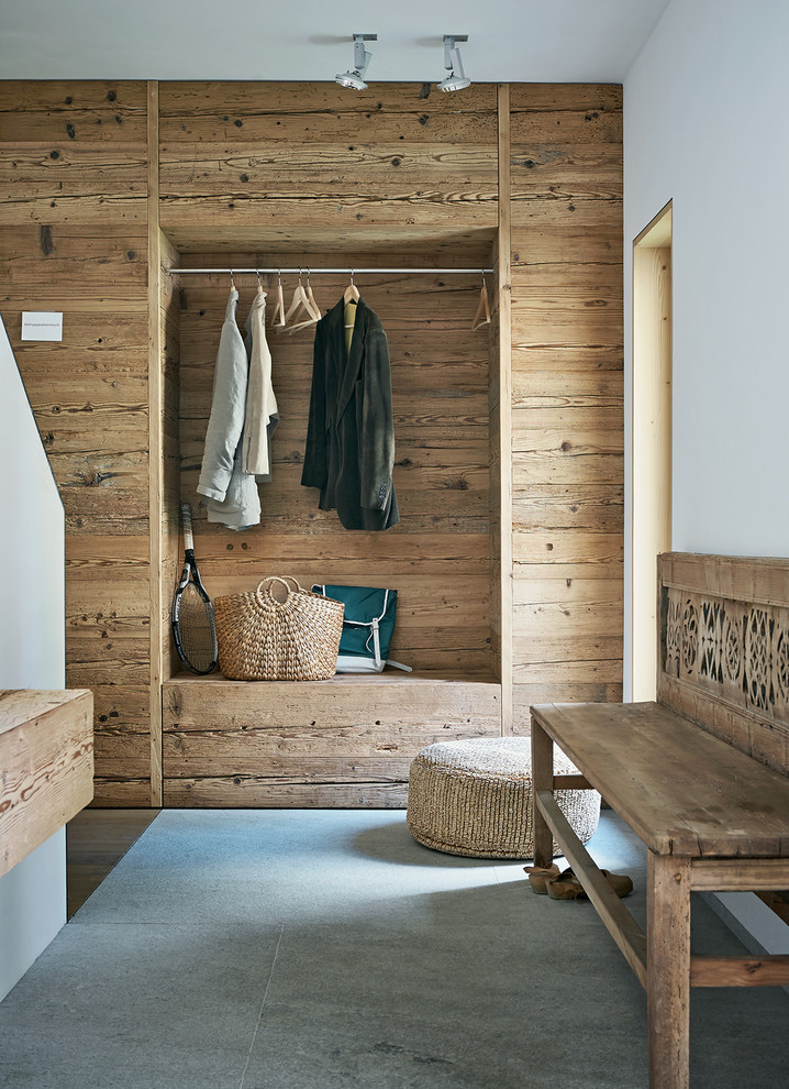 Inspiration for a country mudroom in Hamburg with white walls, concrete floors and grey floor.