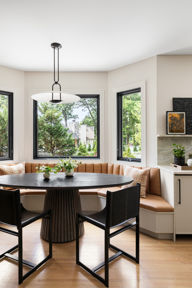 Transitional kitchen/dining combo in New York with white walls, light hardwood floors and brown floor.