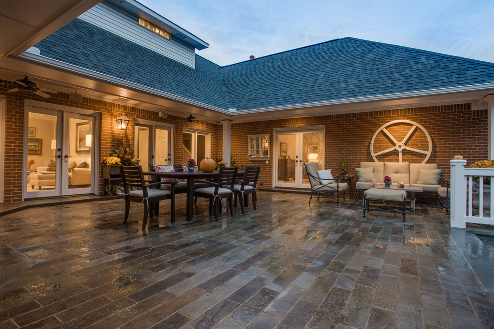 Traditional backyard patio in Dallas with natural stone pavers and no cover.
