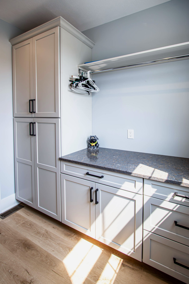 This is an example of a small transitional galley dedicated laundry room in Cleveland with an undermount sink, flat-panel cabinets, grey cabinets, grey walls, laminate floors, a side-by-side washer and dryer and grey benchtop.