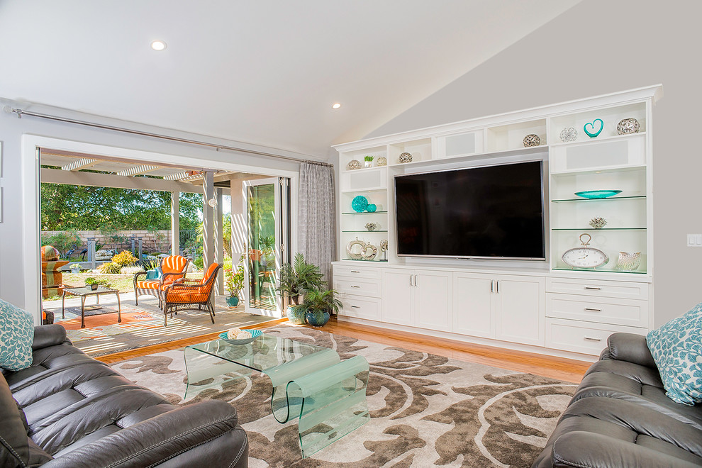 Inspiration for an expansive transitional open concept living room in Los Angeles with grey walls, medium hardwood floors and a built-in media wall.