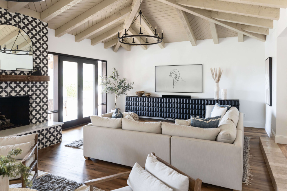 Klassisches Wohnzimmer mit weißer Wandfarbe, braunem Holzboden, Kamin, braunem Boden, freigelegten Dachbalken, gewölbter Decke, Holzdecke und gefliester Kaminumrandung in Phoenix