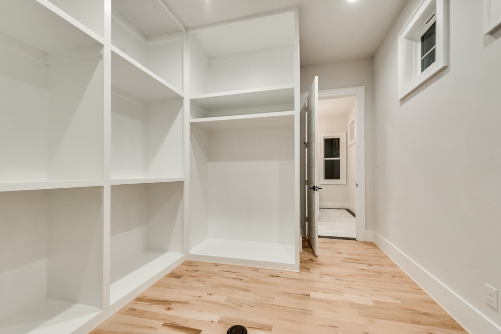 Inspiration for a large contemporary gender-neutral walk-in wardrobe in Dallas with open cabinets, white cabinets, light hardwood floors and multi-coloured floor.