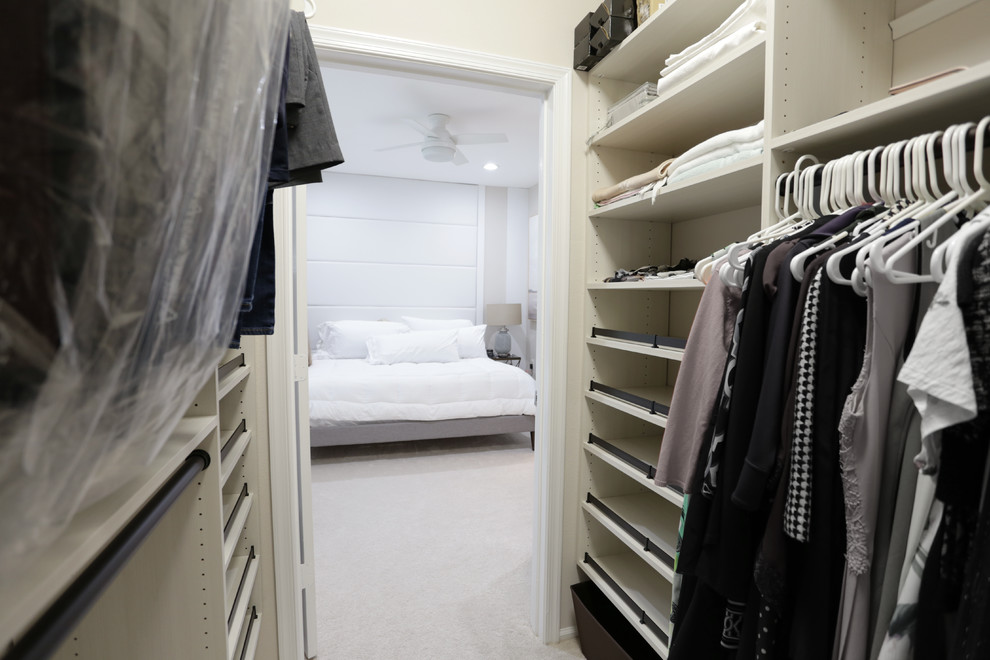 Photo of a mid-sized beach style gender-neutral walk-in wardrobe in DC Metro with open cabinets, white cabinets, carpet and white floor.