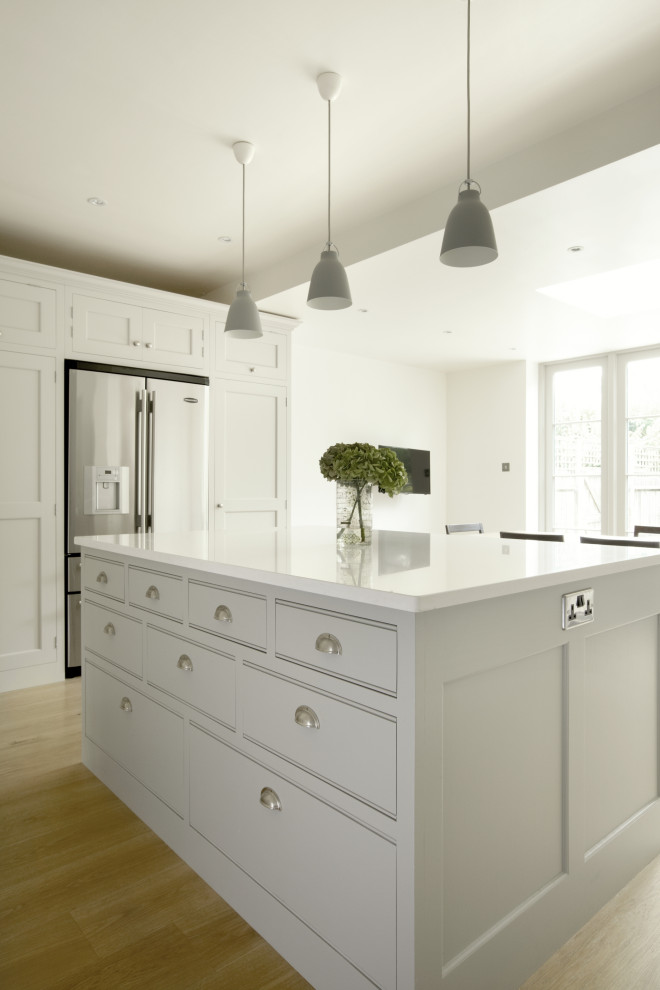 Design ideas for a large traditional kitchen in London with shaker cabinets, grey cabinets, quartzite benchtops, grey splashback, ceramic splashback, light hardwood floors, with island and white benchtop.