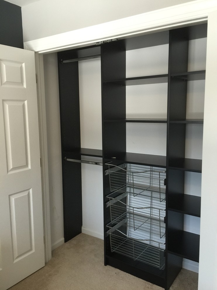 This is an example of a mid-sized transitional gender-neutral built-in wardrobe in Other with carpet, open cabinets and black cabinets.