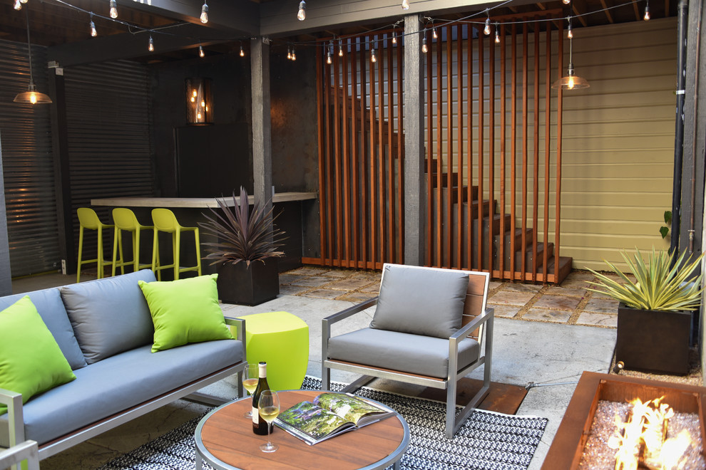 Photo of a large industrial courtyard patio in San Francisco with a fire feature and concrete slab.