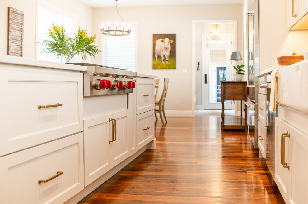 Large transitional l-shaped dark wood floor and brown floor open concept kitchen photo in Denver with a farmhouse sink, shaker cabinets, beige cabinets, quartz countertops, beige backsplash, ceramic backsplash, stainless steel appliances, an island and white countertops