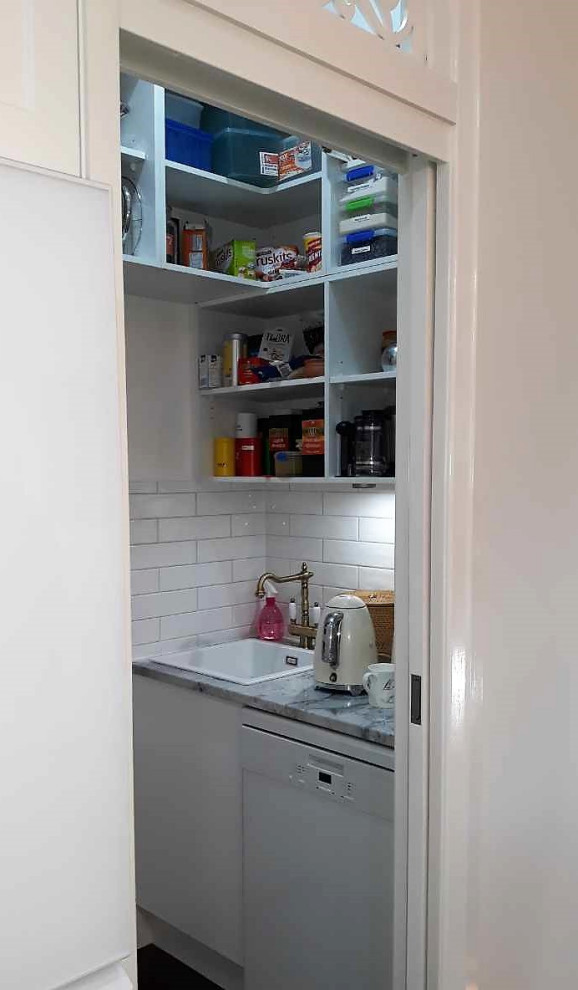 Design ideas for a mid-sized traditional kitchen pantry in Brisbane with a drop-in sink, shaker cabinets, white cabinets, granite benchtops, white splashback, subway tile splashback, white appliances, with island and grey benchtop.
