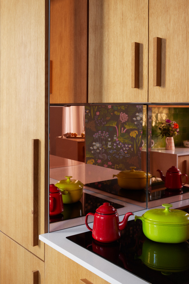 Foto de cocina de tamaño medio con puertas de armario de madera clara, encimera de cuarcita, salpicadero con efecto espejo y encimeras blancas
