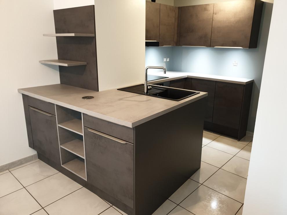 Photo of a small modern u-shaped open plan kitchen in Lyon with ceramic floors, grey benchtop, an undermount sink, beaded inset cabinets, grey cabinets, laminate benchtops, grey splashback, glass sheet splashback, black appliances, a peninsula and white floor.
