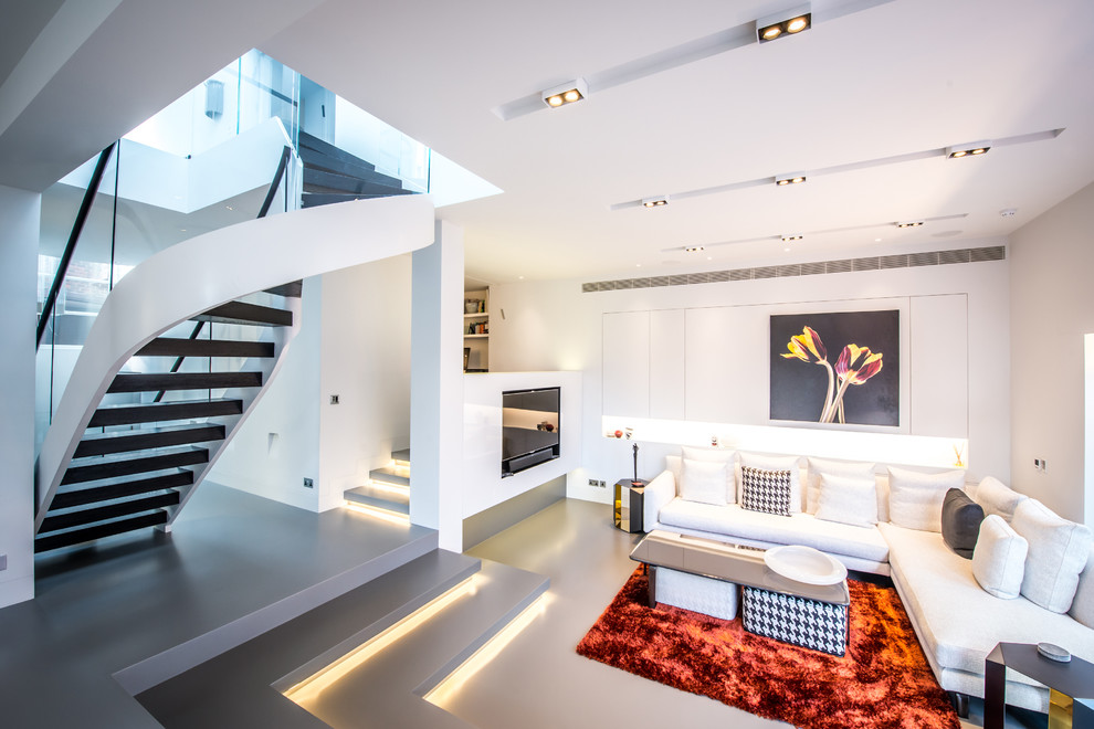 This is an example of a contemporary open concept living room in London with white walls and no fireplace.
