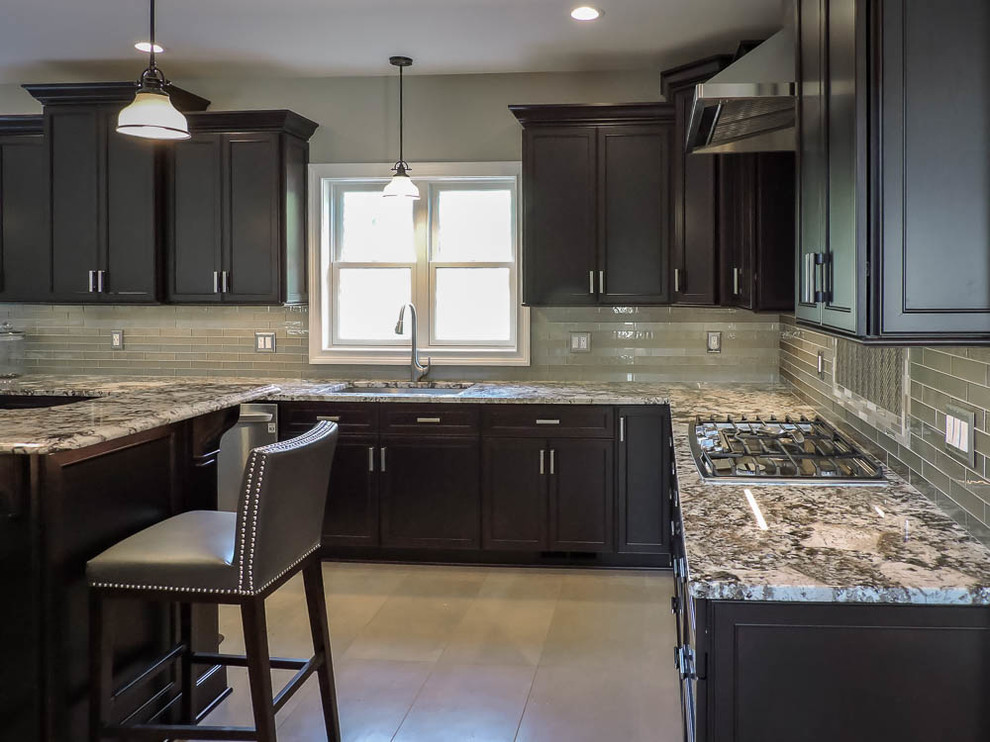 Inspiration for a large transitional u-shaped porcelain tile and beige floor eat-in kitchen remodel in Bridgeport with an undermount sink, raised-panel cabinets, dark wood cabinets, granite countertops, green backsplash, glass tile backsplash, stainless steel appliances, an island and brown countertops