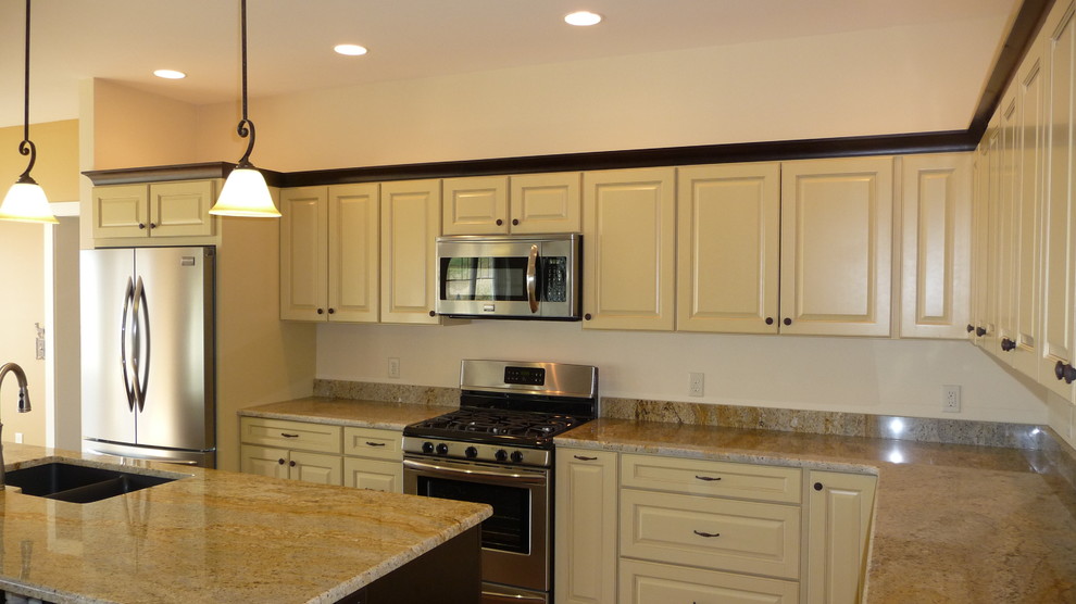 Inspiration for a large transitional l-shaped cork floor open concept kitchen remodel with a double-bowl sink, raised-panel cabinets, yellow cabinets, granite countertops, white backsplash, mosaic tile backsplash, stainless steel appliances and an island
