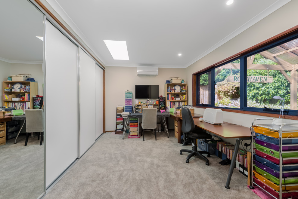 Photo of a mid-sized arts and crafts study room in Melbourne with beige walls, carpet, a freestanding desk and beige floor.