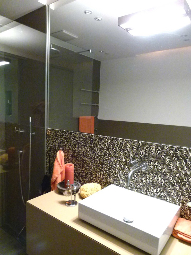 Duschbad With flächenbündigen Schrankfronten, bodengleicher Dusche, Wandtoilette, Mosaikfliesen, weißer Wandfarbe, Keramikboden, Aufsatzwaschbecken, beigen Schränken, Waschtisch aus Holz, Einbaubadewanne and grauen Fliesen in Cologne