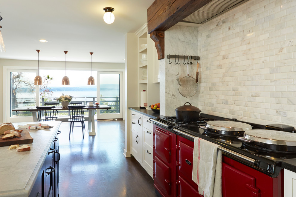 Photo of a traditional eat-in kitchen in Seattle with shaker cabinets, white cabinets, white splashback, coloured appliances, dark hardwood floors and with island.