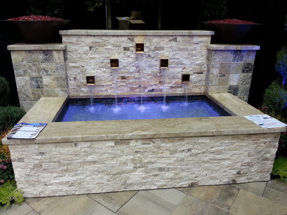 Inspiration for a large traditional backyard rectangular lap pool in Dallas with a water feature and natural stone pavers.