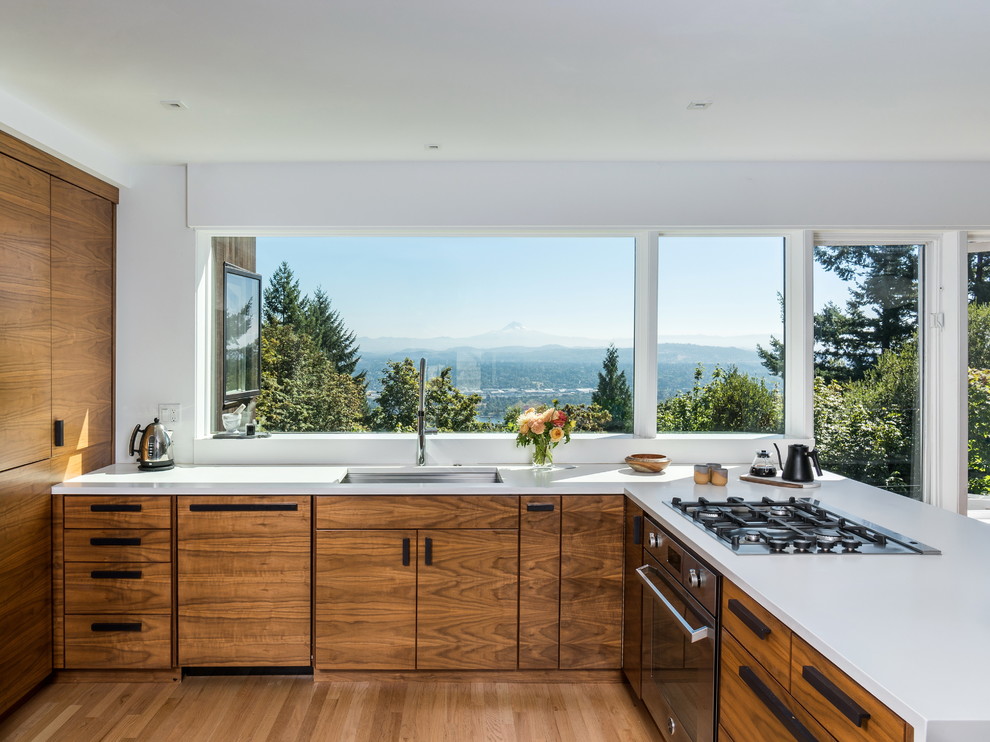 Photo of a contemporary u-shaped eat-in kitchen in Portland with an undermount sink, flat-panel cabinets, medium wood cabinets, panelled appliances, medium hardwood floors, a peninsula and brown floor.
