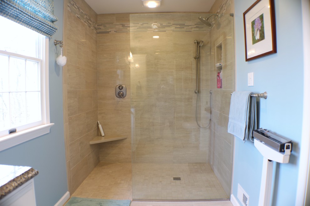 Photo of a large transitional master bathroom in Other with raised-panel cabinets, white cabinets, a curbless shower, a one-piece toilet, beige tile, porcelain tile, blue walls, porcelain floors, an undermount sink and granite benchtops.