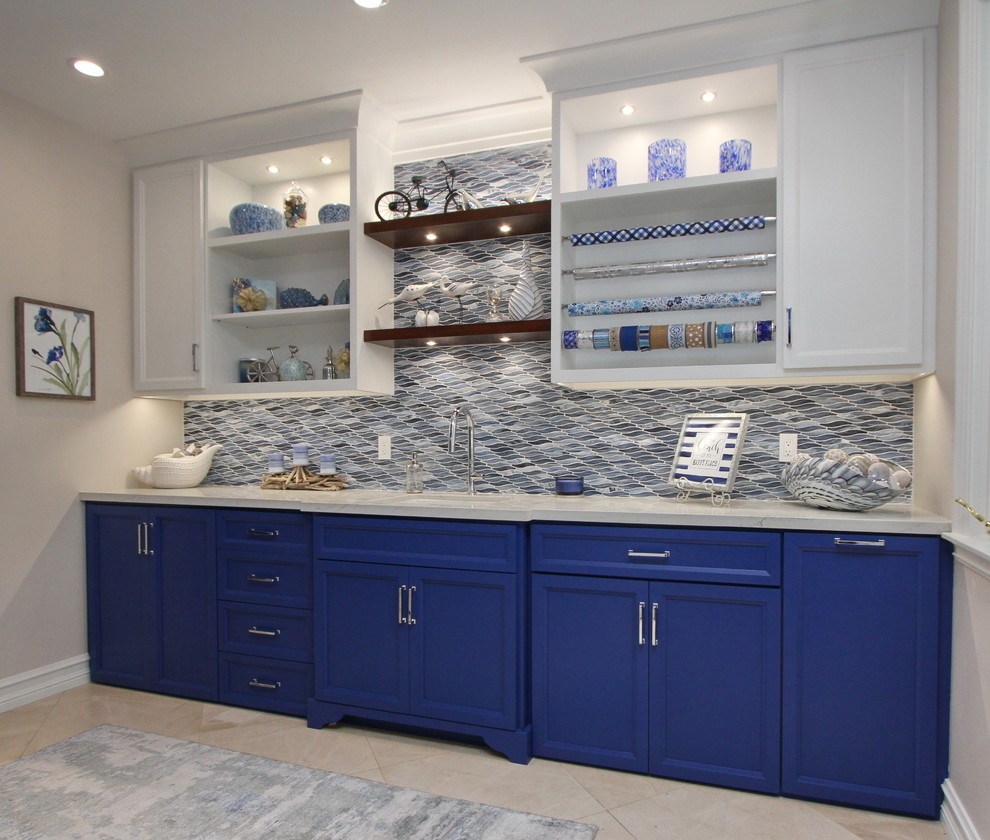 Photo of a large contemporary galley utility room in Orange County with an undermount sink, recessed-panel cabinets, blue cabinets, quartzite benchtops, beige walls, porcelain floors, a side-by-side washer and dryer, beige floor and white benchtop.