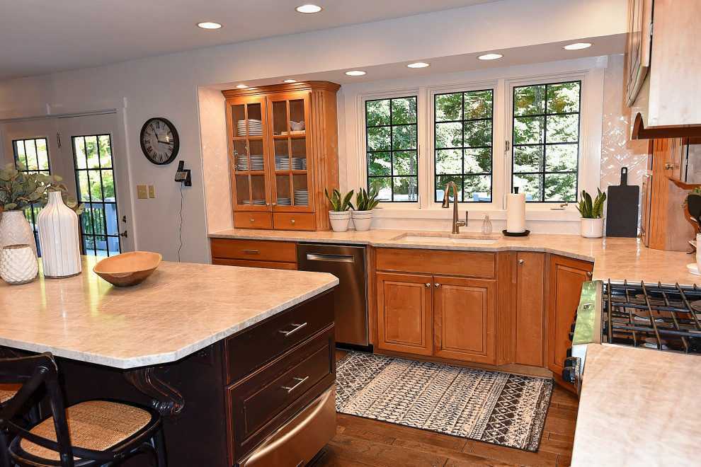 Inspiration for a transitional medium tone wood floor kitchen remodel in Indianapolis with an undermount sink, medium tone wood cabinets, quartzite countertops, white backsplash, ceramic backsplash, an island and beige countertops