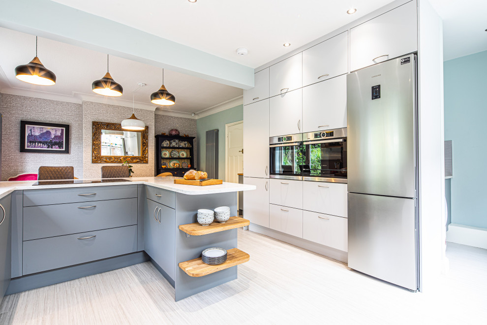 This is an example of a large contemporary u-shaped eat-in kitchen in Other with a double-bowl sink, flat-panel cabinets, grey cabinets, quartzite benchtops, grey splashback, porcelain splashback, panelled appliances, linoleum floors, a peninsula, grey floor and white benchtop.