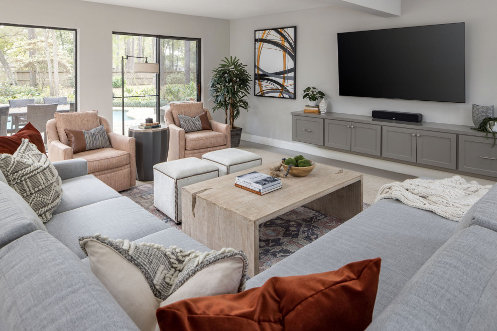 На фото: гостиная комната в стиле неоклассика (современная классика) с серыми стенами, телевизором на стене и серым полом