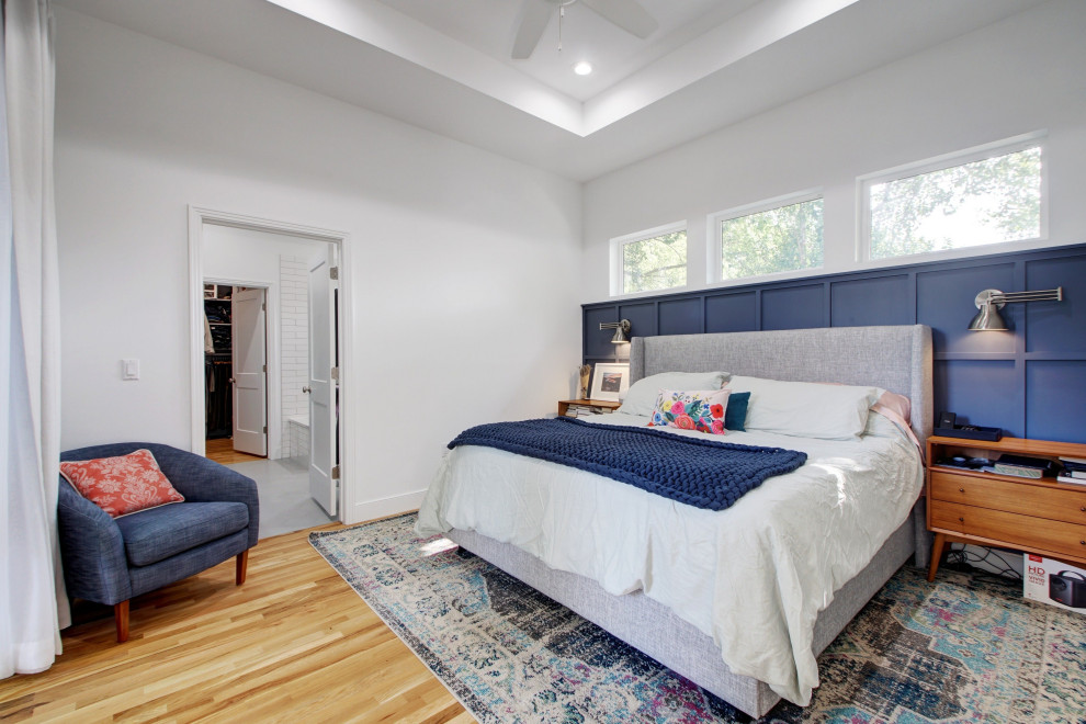 Imagen de dormitorio principal clásico renovado de tamaño medio sin chimenea con paredes blancas, suelo de madera clara, suelo beige, bandeja y panelado